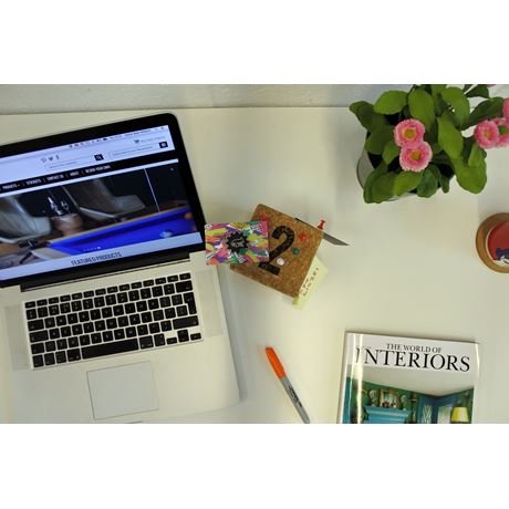 cork cube on desk with computer and magazine