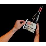 person peeling wine label off the wine bottle